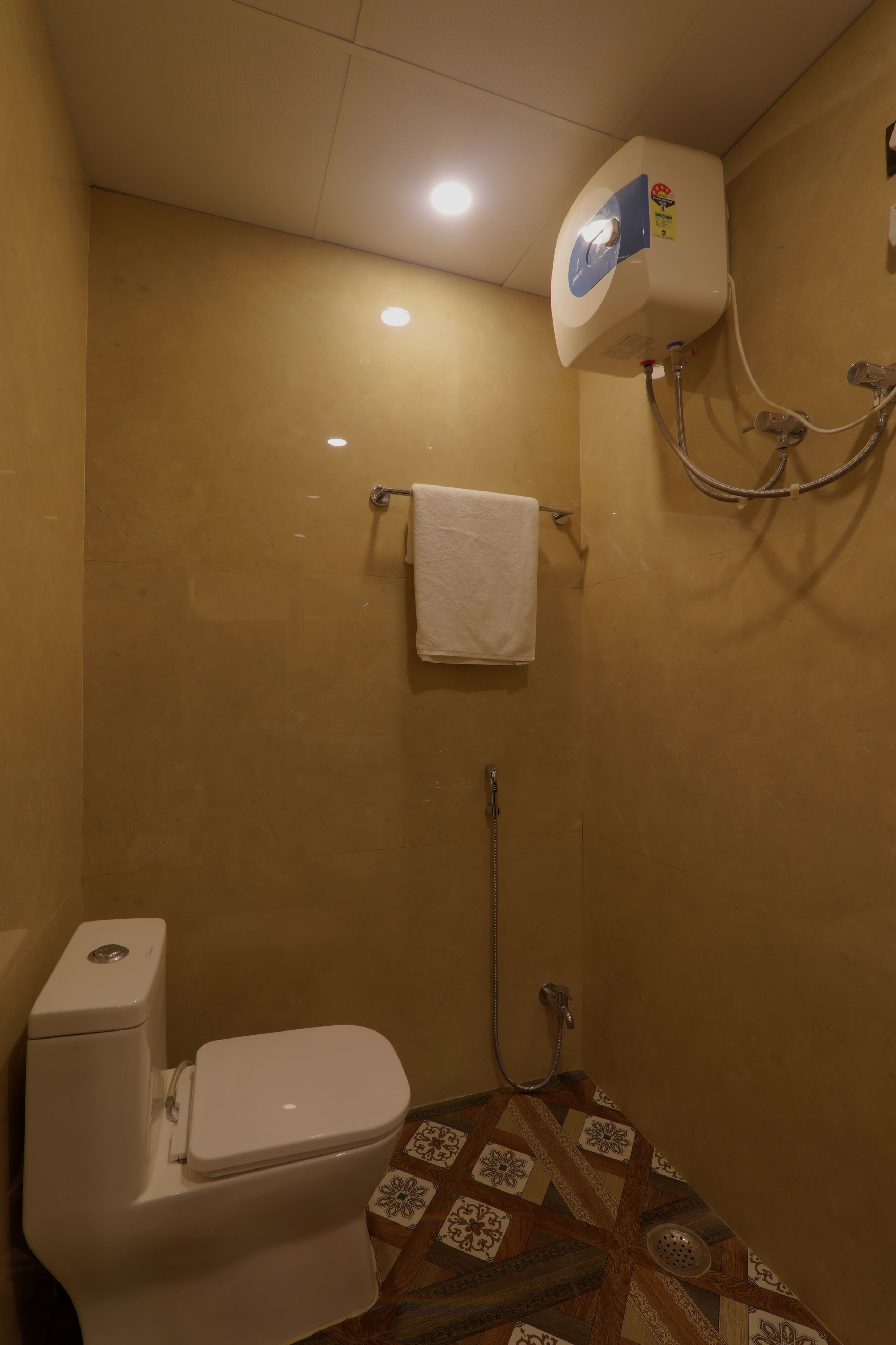 Ein kleines Badezimmer mit Toilette, Dusche und einem Handtuch an der Wand.