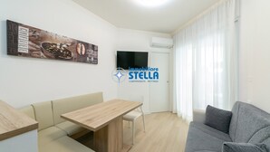 Un soggiorno moderno con divano, tavolo da pranzo e televisore.