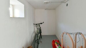 A narrow hallway with a bicycle leaning against the wall, a small red toy car, and a wooden rack with a rope. - Dolní Lysečiny by Interhome (Horní Maršov/Pec pod Sněžkou)