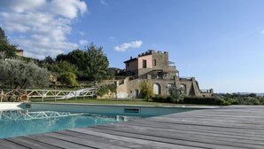 A stone building with a pool and wooden deck. - Villa Torresassa - Villa with pool near Montaione, Tuscany (Iano)
