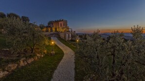 A stone pathway leading to a castle-like building with a view of the sunset. - Villa Torresassa - Villa with pool near Montaione, Tuscany (Iano)