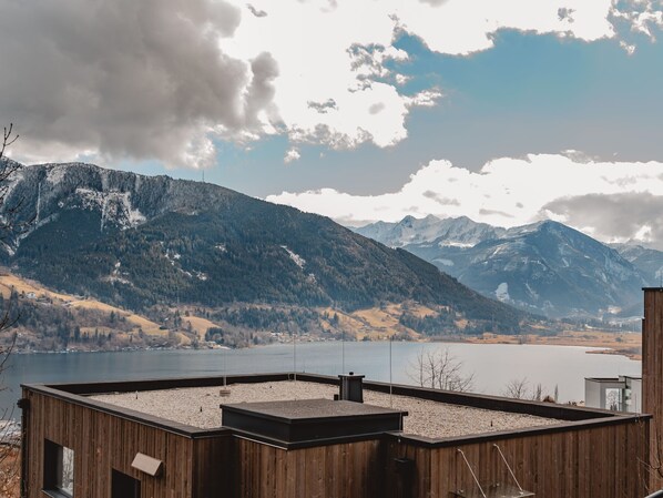 Una cabaña de madera con vistas a un lago y montañas.