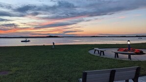 A park with a bench and a lamp post, overlooking a body of water at sunset. - Charming 3-Bedroom Wildwood Crest Spot: Beach, Bay, and Boardwalk- all so close! (Wildwood)