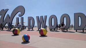 A beach area with large letters spelling "WILDWOOD" and two colorful beach balls in the foreground. - Charming 3-Bedroom Wildwood Crest Spot: Beach, Bay, and Boardwalk- all so close! (Wildwood)