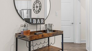 Un espace bar avec un comptoir en bois, une horloge et une enseigne sur laquelle on peut lire « BAR ».