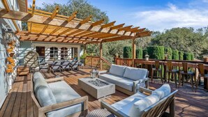 A wooden deck with outdoor furniture, including sofas and chairs, and a pergola structure. - The Curated Haven, by Vinifera Homes (Sonoma)