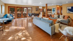 A spacious living room with a large sofa, a dining area, and a kitchen. - The Curated Haven, by Vinifera Homes (Sonoma)