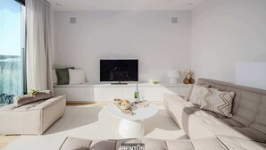 Una sala de estar moderna con un sofá, una mesita de centro y un televisor.