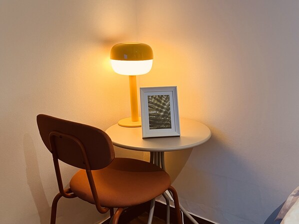A chair and a table with a lamp and a framed picture. - Feeling Motel (Gwangmyeong)