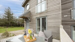 A modern house with a deck, a dining table with a tray of food, and a chair. - 55 Una -  Spa Access and Free Parking (Carbis Bay)