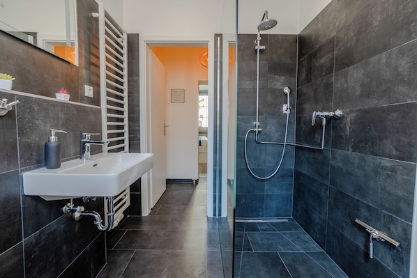 Apartamento conforto, vista para o jardim | Banheiro | Chuveiro, secador de cabelo, toalhas de banho, sabonete