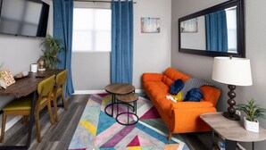 Ein modernes Wohnzimmer mit einer Couch, einem Couchtisch und einem Fernseher.