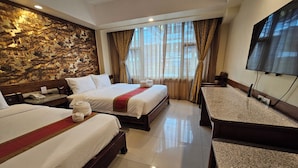 A hotel room with two beds, a television, a stone wall mural, and a window with curtains. - The Class Boutique Hotel (Pattaya)