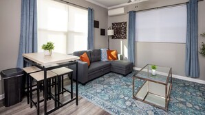 Un salon moderne avec un canapé, une table basse et un coin repas.