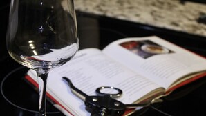 A clear glass of water, an open book, and a pair of scissors on a black surface. - Relax & Explore Downtown Little Rock (Little Rock)