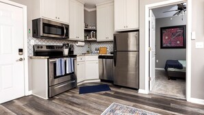 A compact kitchen with white cabinetry, stainless steel appliances, and a wooden floor. - Central Little Rock:Pet Friendly|Near Park |Museum (Little Rock)