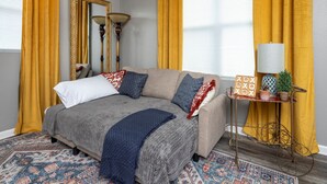 A cozy living room with a sofa, patterned rug, and a small table with decorative items. - Central Little Rock:Pet Friendly|Near Park |Museum (Little Rock)