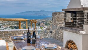 Taula preparada per a dinar amb vista al mar i a les muntanyes.