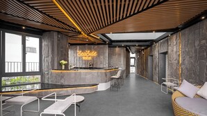 A modern hotel lobby with a reception desk, seating area, and a large window offering a view. - Seaside Boutique Hotel Nha Trang Beach (Nha Trang)