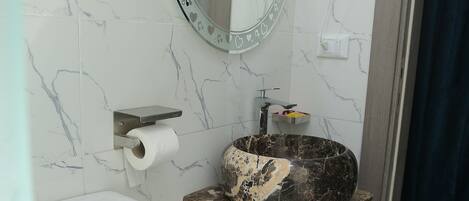 Un baño con inodoro, lavabo y espejo.