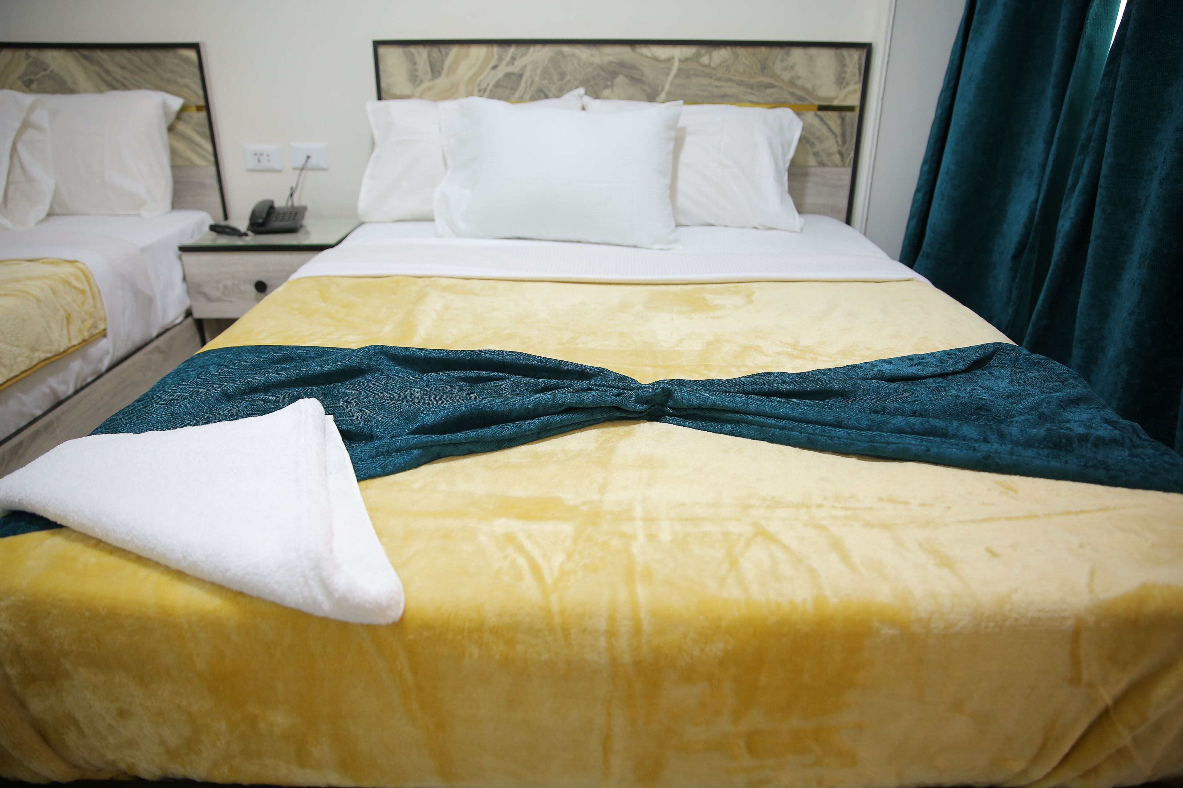 Ein Hotelzimmer mit Bett, Nachttisch und Telefon.