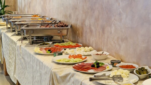 A buffet table with various food items and utensils. - Divski Wellness Resort (Divcibare)