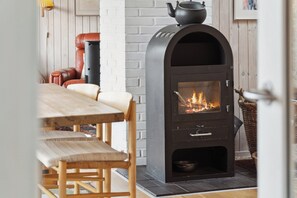 A room with a fireplace, a dining table, and chairs.