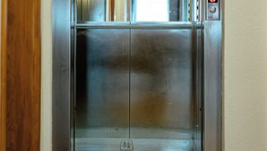 An elevator with a metallic finish, a digital display, and a reflective surface. - Pension Silvia (Medjugorje)