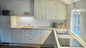Eine moderne Küche mit weißen Schränken, einer Edelstahl-Spüle und Holzboden.