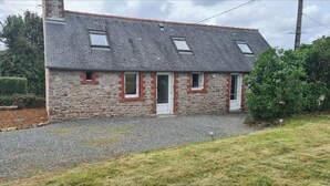A stone building with a sloped roof, two windows, and a door. - Atypical house at the entrance to Paimpol (Kerfot)