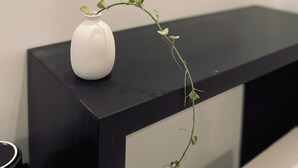 A white vase with a plant on a black console table. - Ben Ben Hotel (Xuan Huong - Da Lat)