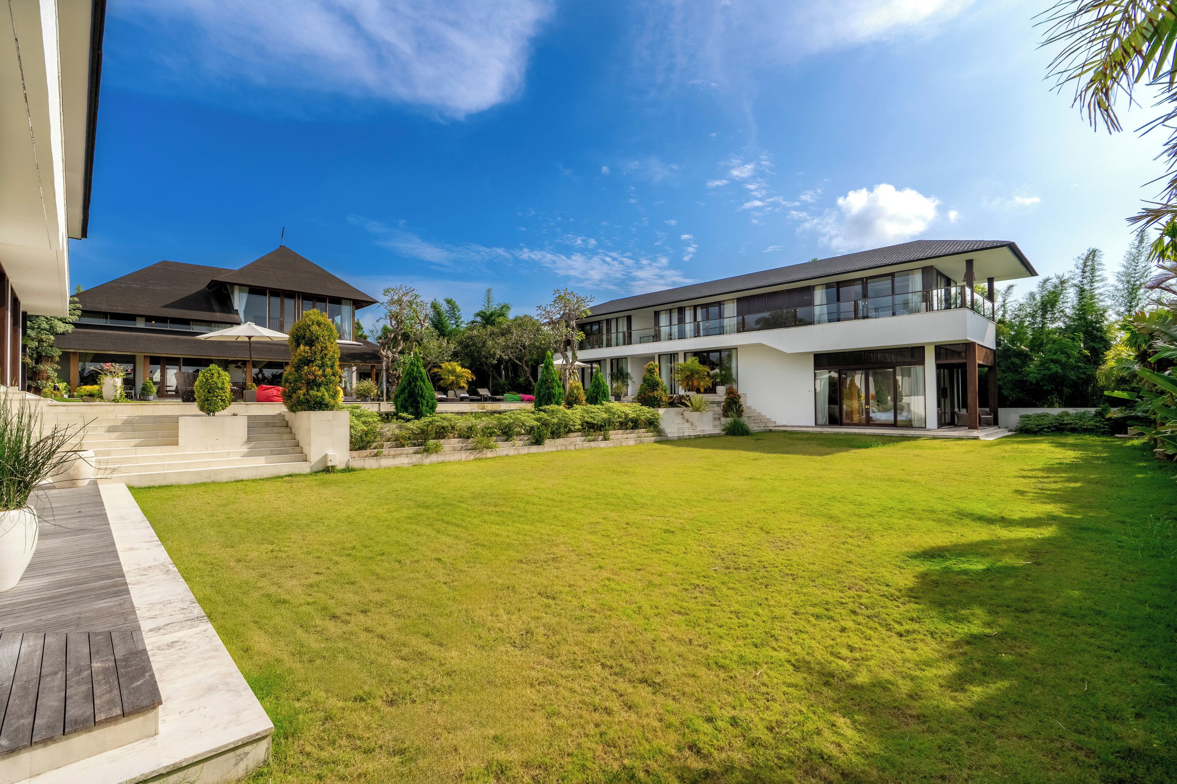 A modern two-story house with a well-maintained lawn and a patio area.