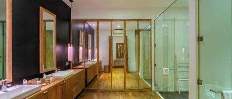 A modern bathroom with wooden cabinets, multiple sinks, and large mirrors.