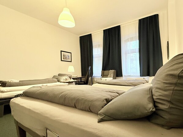 Une chambre d’hôtel avec un lit, un bureau, une chaise et une lampe.