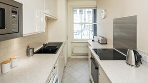 Une cuisine moderne équipée d’un four à micro-ondes Bosch, d’une bouilloire et d’un grille-pain.