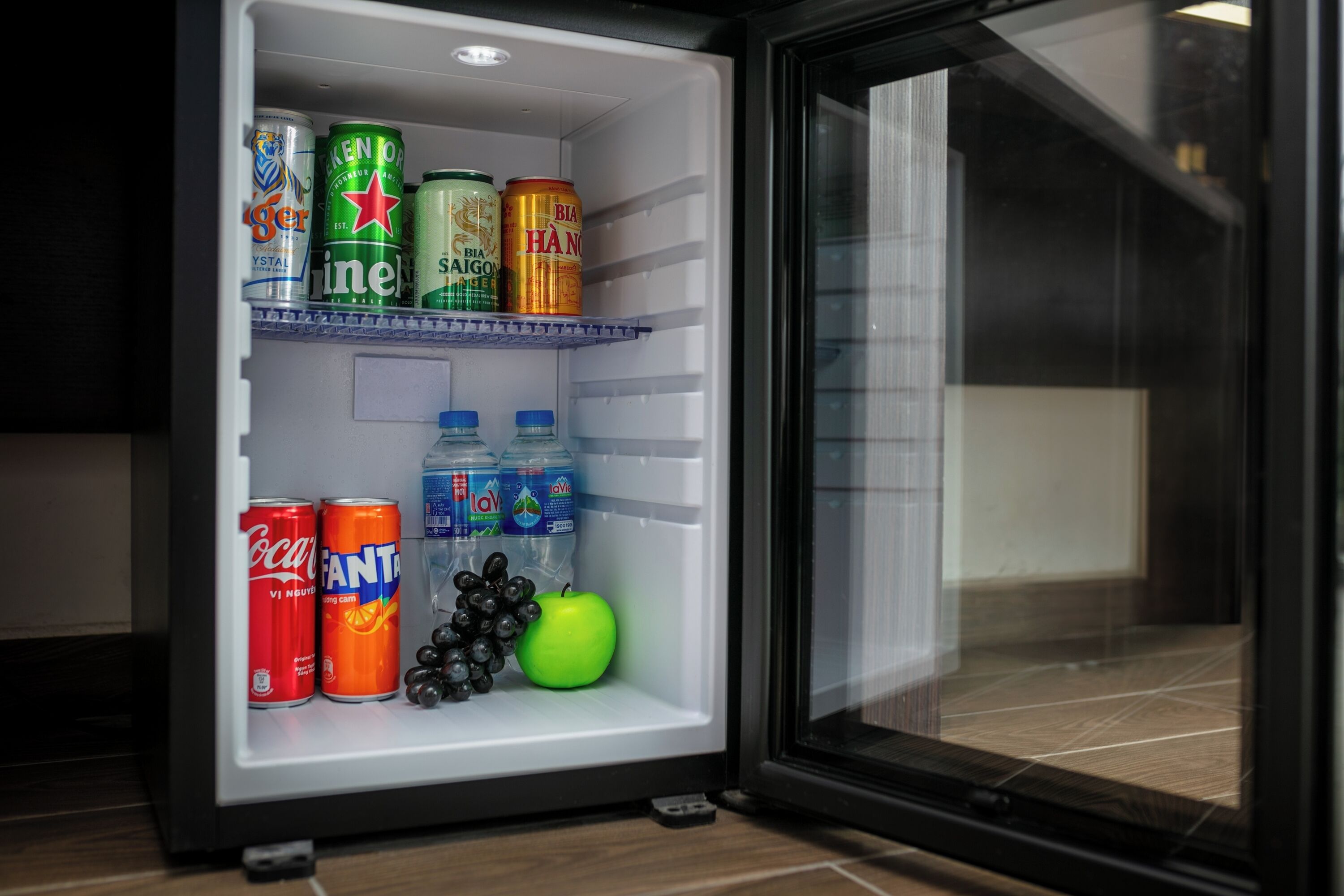 A refrigerator stocked with beverages and fruits.
