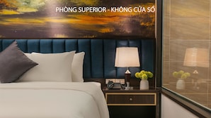 A hotel room with a bed, a nightstand, a lamp, and a vase with flowers.