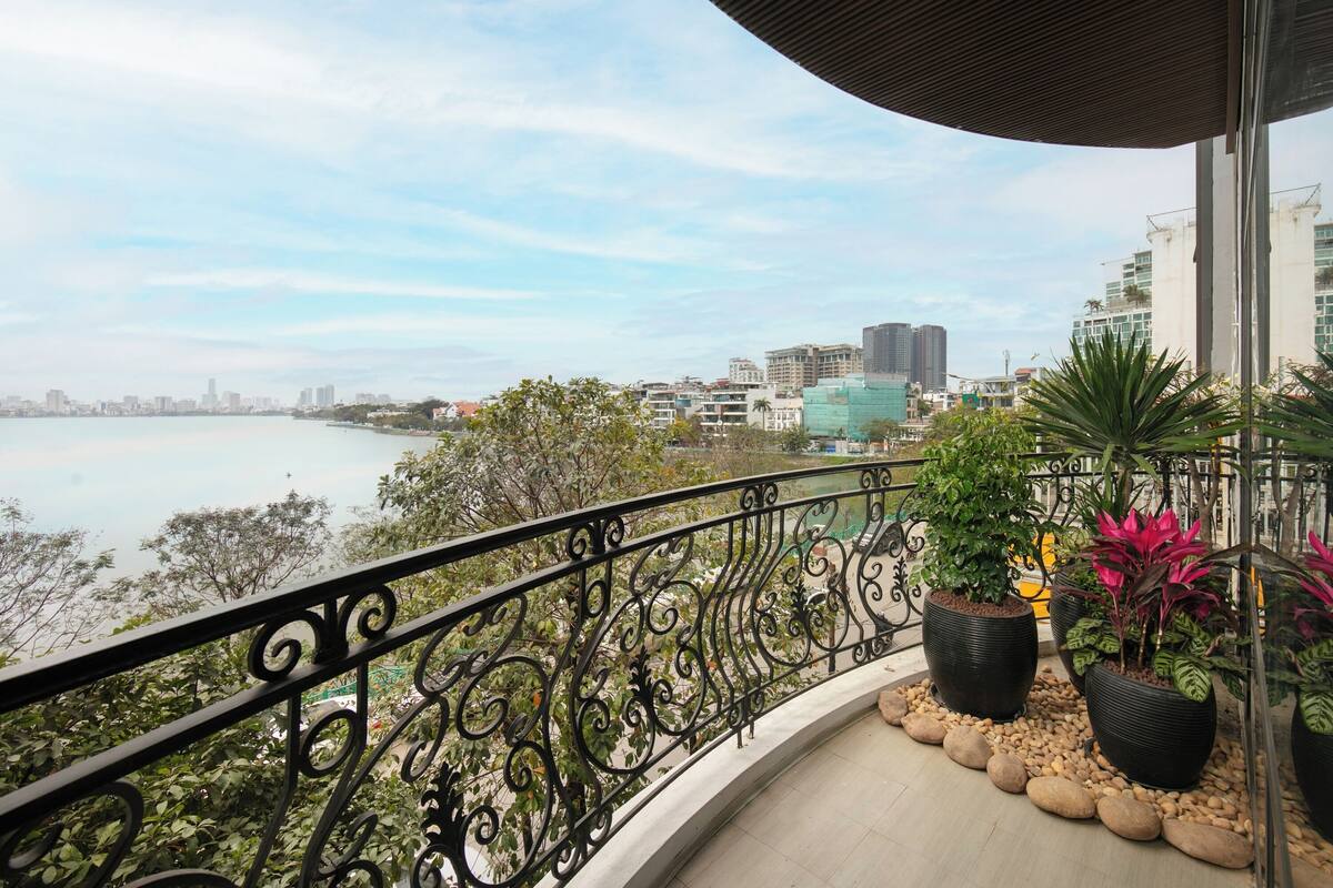 A balcony with a view of a city skyline and a body of water.