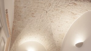 A room with a stone ceiling, a door, and a light fixture. - Ladorea Suite - Cozy accommodation with private terrace (San Michele Salentino)
