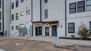 A multi-story residential building with a clean, white exterior and a gated entrance.