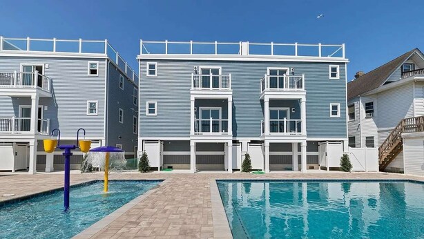 En bostadsbyggnad med en swimmingpool och ett vattenspel.