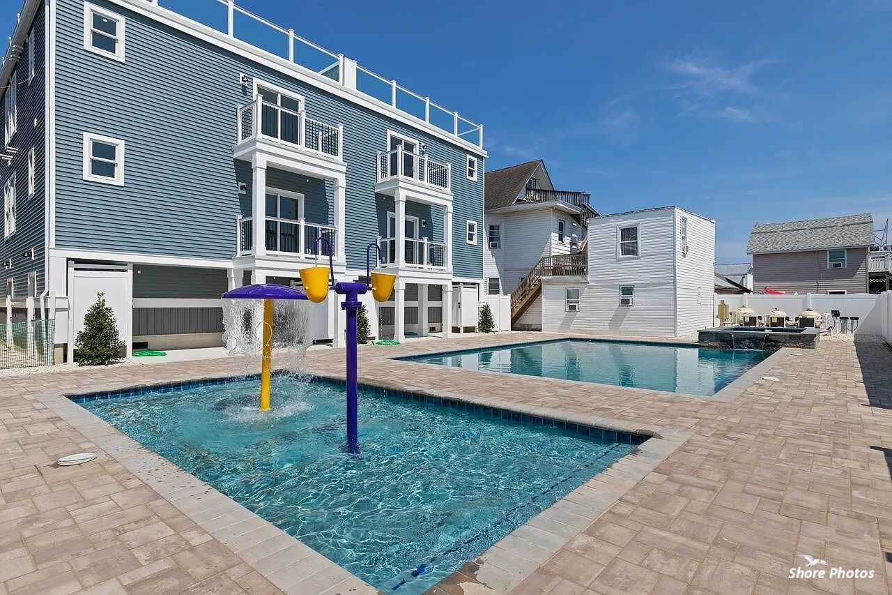A pool area with a water feature and a multi-story building in the background.