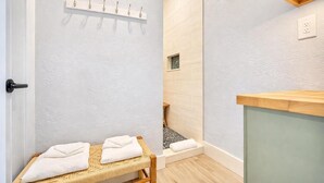 A spa room with a wooden bench, a towel rack, and a wooden counter.
