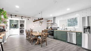 A modern kitchen with wooden dining table and chairs, green cabinets, and a built-in oven. - Hot Tub, Grill, Fire Pit / 25 mins to Grand Canyon (Grand Canyon Junction)