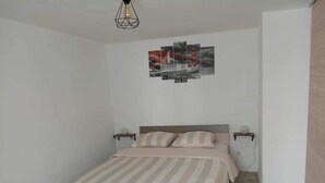 Ein Schlafzimmer mit einem Bett, Nachttischen und einem Wandbild.