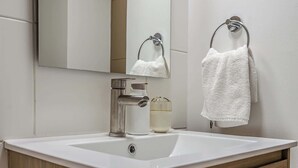 A bathroom with a white sink, chrome faucet, and a glass bottle of soap. - Charming 1BR in Santiago, WiFi & Equipped Kitchen (Unknown)