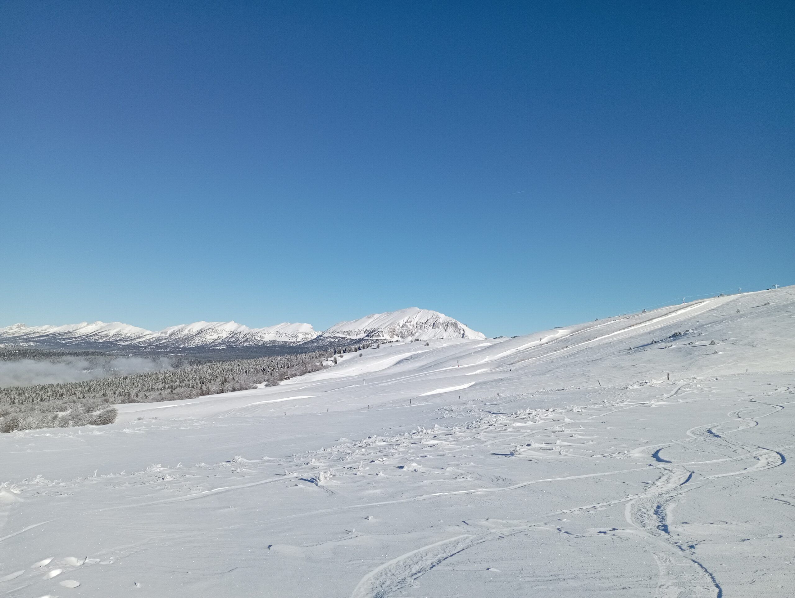 A snowy mountain landscape with clear skies.