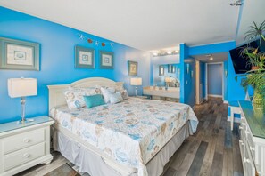 Un dormitorio con cama, mesitas de noche, cómoda y espejo.