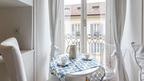 Ein Balkon mit einem Tisch für zwei Personen, einem Wasserkocher und einer Tasse.