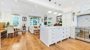 A spacious kitchen with white cabinetry, a central island, and a built-in oven.